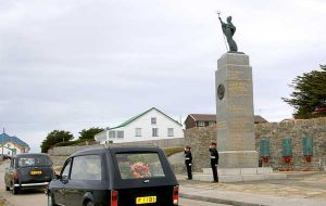 As it passes the 1982 Liberation Monument, the hearse carrying Mr Peck's coffin is saluted by Privates Craig Paice and Zoran Zuvic of the Falkland Islands Defence Force.